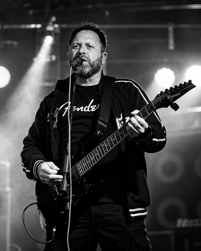 Michael Schönewald singt am Mikrofon und spielt Gitarre