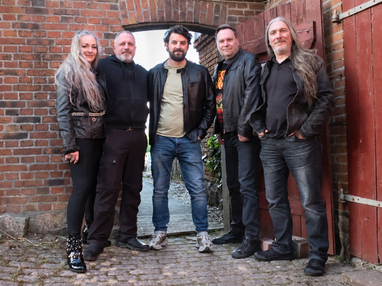 Die fünf Musikerinnen und Musiker von Nobody's Wife in einem Backsteinhof